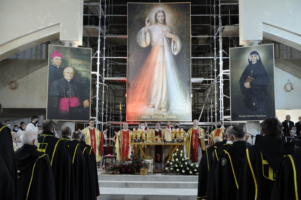 Enormous image of divine mercy, flanked by smaller canvases of St. Faustina and clerical sponsor, hang above altar while Mass is celebrated. 