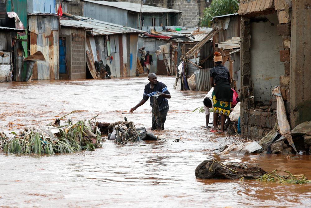 Residents wade through flood waters as they recover their belongings in the Mathare Valley settlement of Nairobi, Kenya, April 24, 2024, after the Nairobi River burst its bank. (OSV News photo/Monicah Mwangi, Reuters)