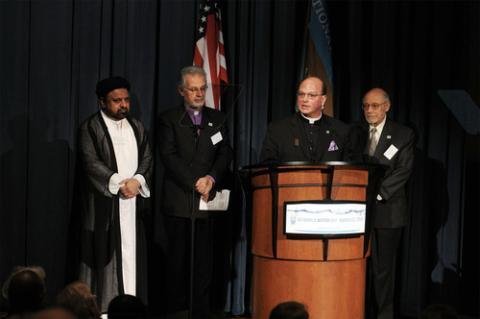 Interfaith clergy assembled by lectern at World Water Day.