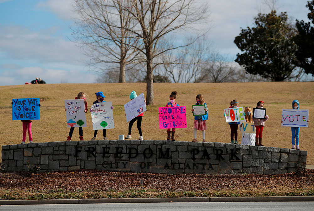 Girl Scouts in Atlanta hold signs urging residents to vote in the runoff election for both of Georgia's U.S. Senate seats Jan. 3. (CNS/Reuters/Brian Snyder)