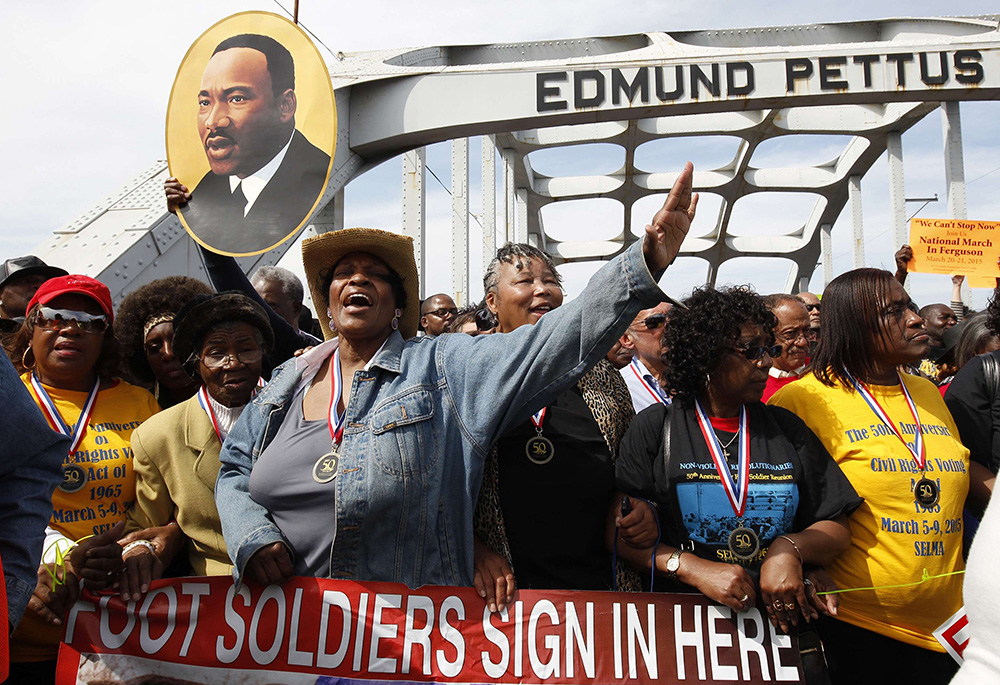 Dorothy Tillman Wright, center, one of the original "foot soldiers" who marched on Bloody Sunday in 1965, shouts March 8, 2015, during a prayer on the Edmund Pettus Bridge in Selma, Alabama. (CNS)