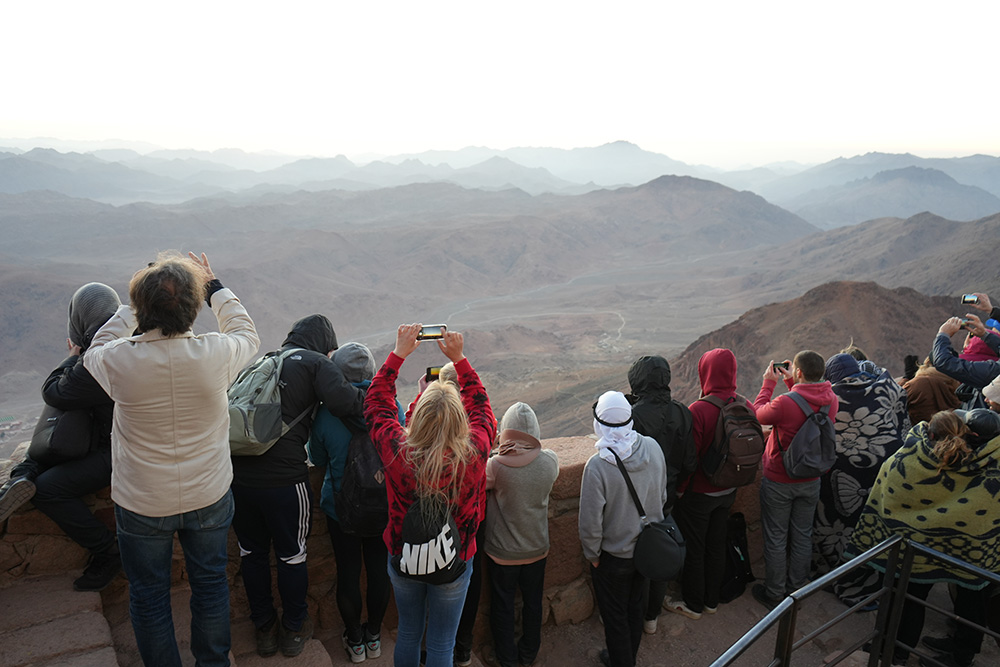 People gather at the peak of Mount Sinai Nov. 14 to take photos of the sunrise, while others offer prayers as they believe it was the time the Ten Commandments were delivered to Moses. (EarthBeat photo/Doreen Ajiambo)