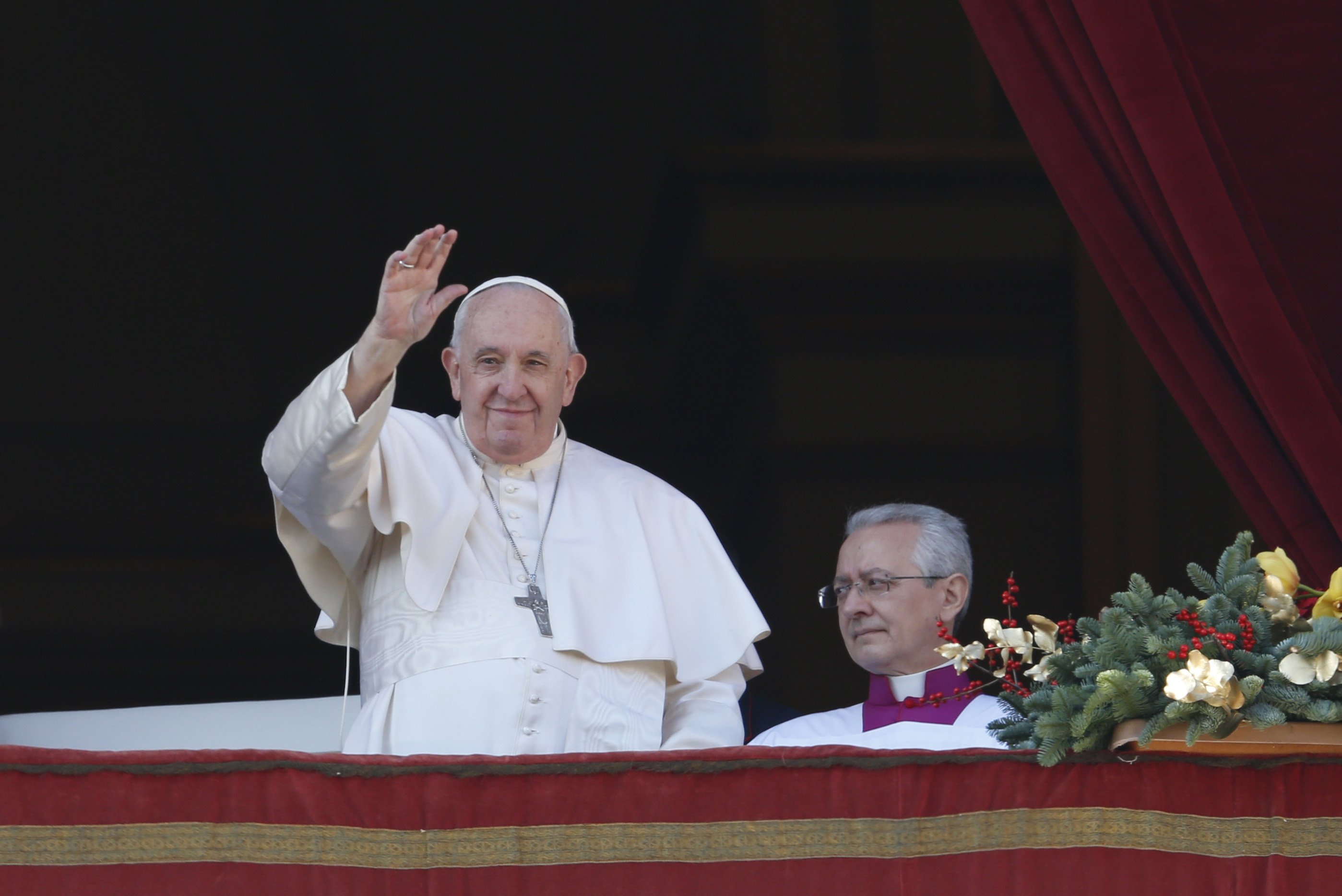 Pope Francis greets the crowd as he arrives to deliver his Christmas message and his blessing "urbi et orbi" (to the city and the world) from the central balcony of St. Peter's Basilica at the Vatican Dec. 25, 2022.