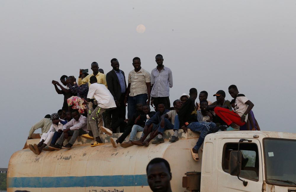 Young men sit on a truck as they attend an ecumenical prayer service attended by Pope Francis at the John Garang Mausoleum in Juba, South Sudan, Feb. 4, 2023. (CNS photo/Paul Haring)