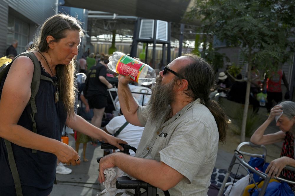 Jillian Andrews and her husband, Douglas Andrews, share water at the Courtyard Homeless Resource Center during an excessive heat warning in Las Vegas July 17, 2023. (OSV News/Reuters/Bridget Bennett)