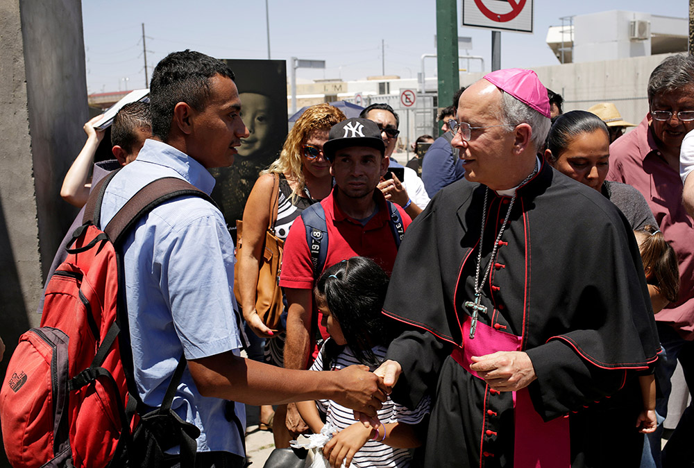 Bishop Mark Seitz of El Paso, Texas, greets a Salvadoran migrant in Ciudad Juárez, Mexico, June 27, 2019. The migrant was deported after crossing the Paso del Norte international border from El Paso. (OSV News/Reuters/Jose Luis Gonzalez)