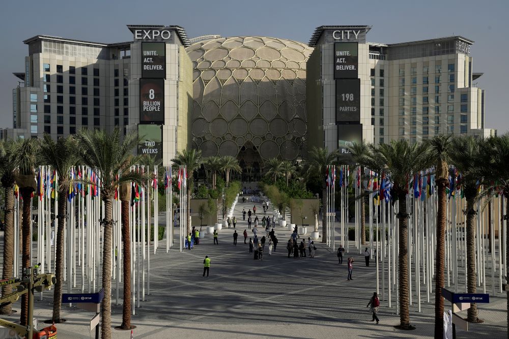 People walk through the venue for the COP28 U.N. Climate Summit, with the Al Wasl Dome in the background, at Expo City, Nov. 29, 2023, in Dubai, United Arab Emirates. (AP/Joshua A. Bickel)