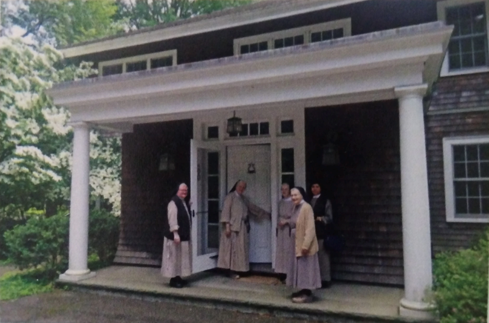 Boston Poor Clare sisters stand in front of their new monastery in Westwood, a Boston suburb. Their previous monastery, which could accommodate 70 sisters, was too big for the congregation. (Courtesy of the Poor Clares of Boston)