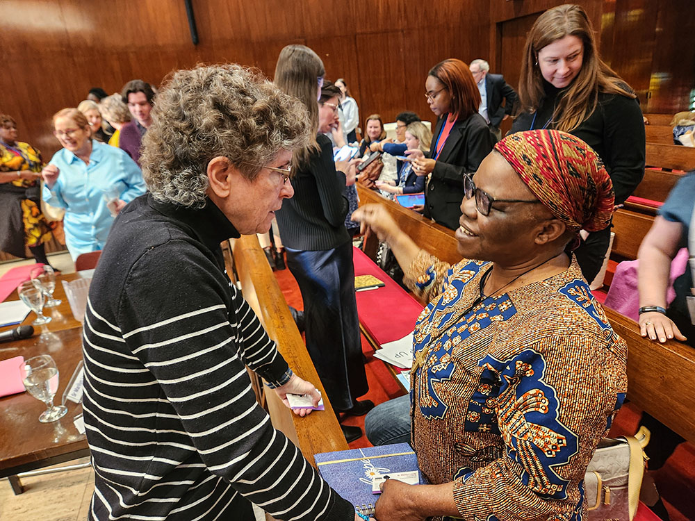 During a March 15 event, "Financing with Dignity," at the Church Center of the United Nations, panelist Mercy Sr. Marilyn Lacey, left, founder and executive director of the international nonprofit Mercy Beyond Borders, speaks to Notre Dame de Namur Sr. Isabelle Izika, right, who represents her order at the U.N. (GSR photo/Chris Herlinger)