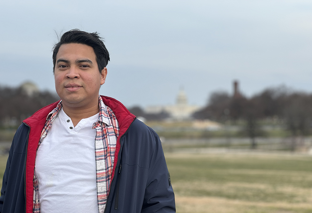 Miguel Flores talks about his experience of leaving his home country of Nicaragua almost a year ago, near the Washington Monument on Feb. 22. Along with 221 other Nicaraguans, which included priests, he was sent on a plane bound for Washington Feb. 9, 2023, and stripped of his nationality. (NCR photo/Rhina Guidos)