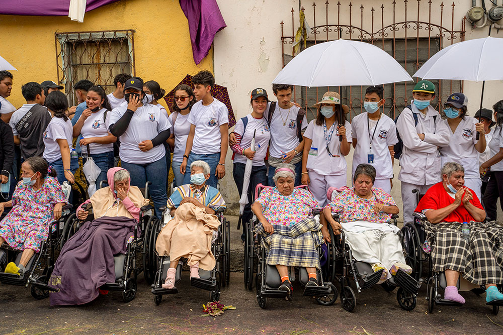 Faithful, accompanied by their nurses and volunteers, wait to watch the annual Jesus del Consuelo procession in Guatemala City March 23. As more than 100 men carrying a religious float halted nearby, Cardinal Álvaro Ramazzini lost no time in calling for social justice — the hallmark of the Catholic bishop’s decades-long frontline ministry. (AP/Moises Castillo)