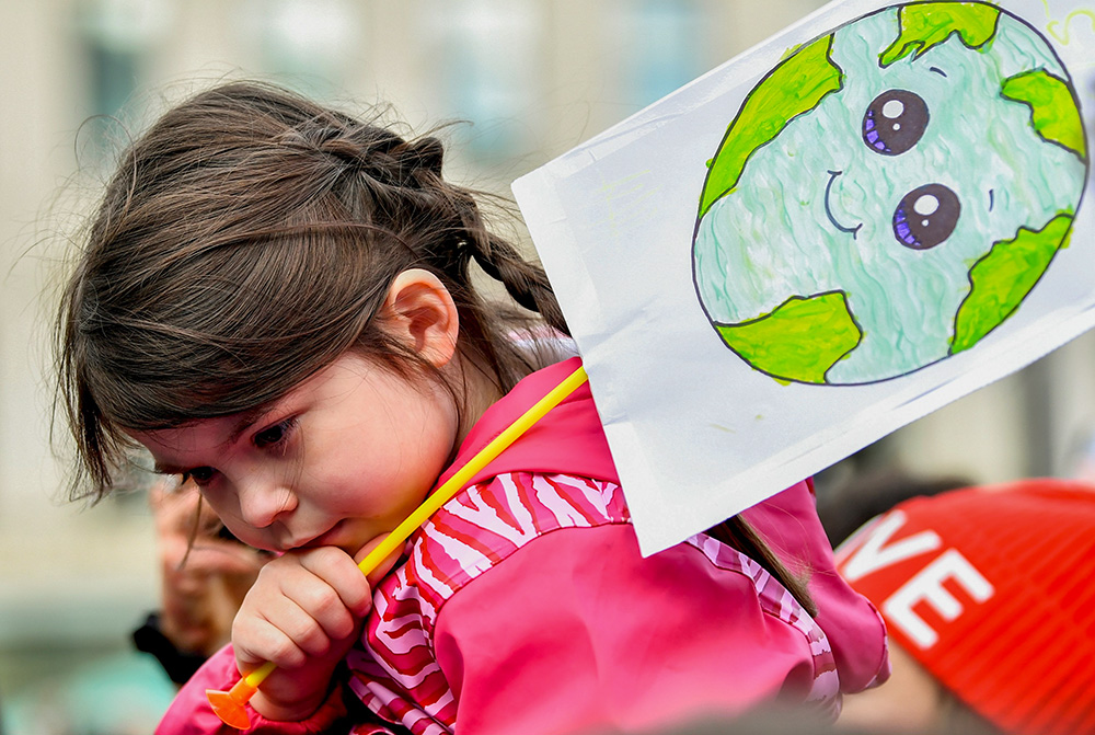A child holds a placard at a "Fridays for Future" march Nov. 5, 2021, during the COP26 U.N. Climate Summit in Glasgow, Scotland. (CNS/Reuters/Dylan Martinez)