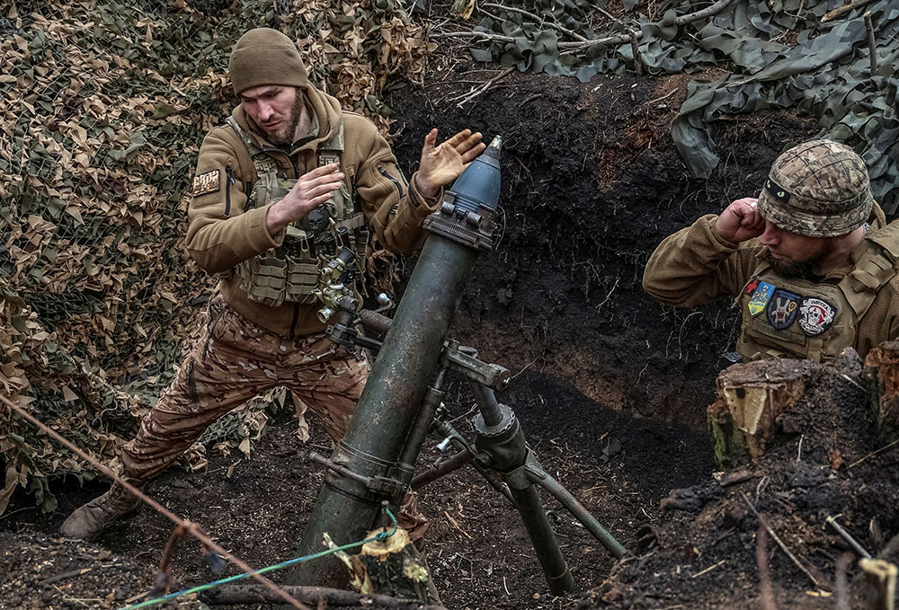 Ukrainian servicemen of the 28th Separate Mechanized Brigade fire a 120-mm mortar toward Russian troops at a frontline, amid Russia's attack on Ukraine, near the town of Bakhmut, Ukraine, March 15. (OSV News/Reuters/Oleksandr Ratushniak)