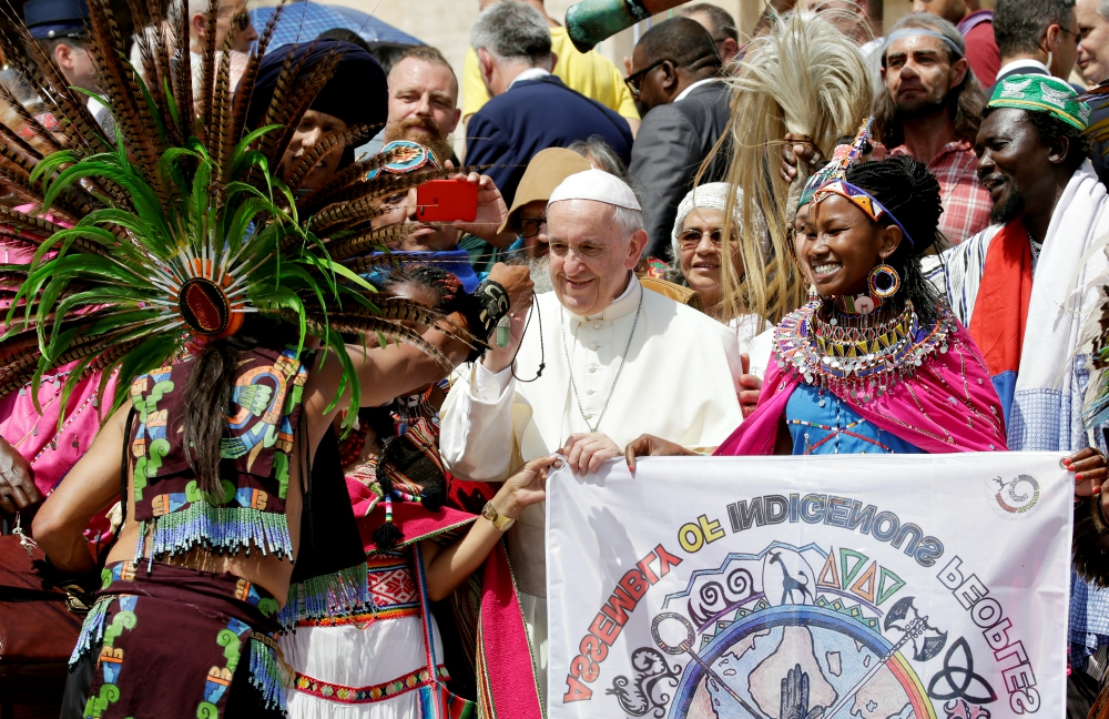 Pope Francis receives a gift during a meeting with members of the Assembly of Indigenous Peoples after his general audience in St. Peter's Square at the Vatican May 30, 2018. (CNS/Reuters/Max Rossi)