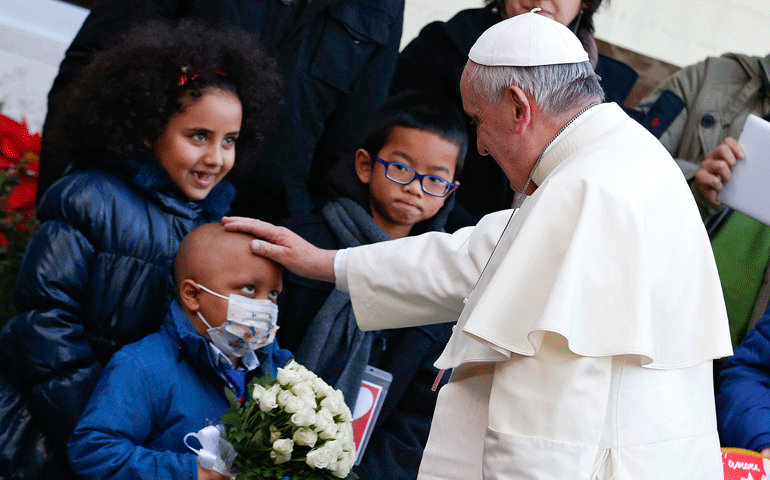 Pope Francis blesses a sick child as he arrives to visit the Bambino Gesù Hospital in Rome Dec. 21. (CNS/Reuters/Alessandro Bianchi)