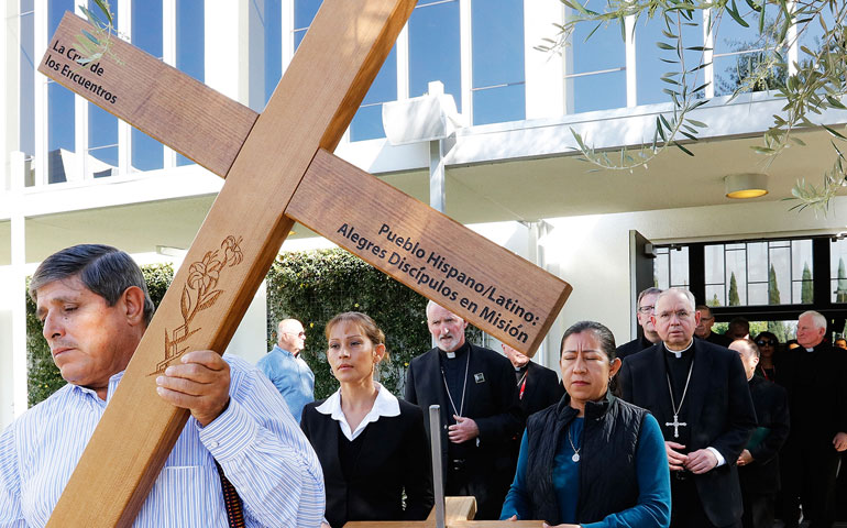 A man carries a cross ahead of a Feb. 27 procession that includes several Southern California bishops, during the second annual Immigration Summit, which took place at Christ Cathedral in Garden Grove, Calif. (CNS/Victor Aleman)