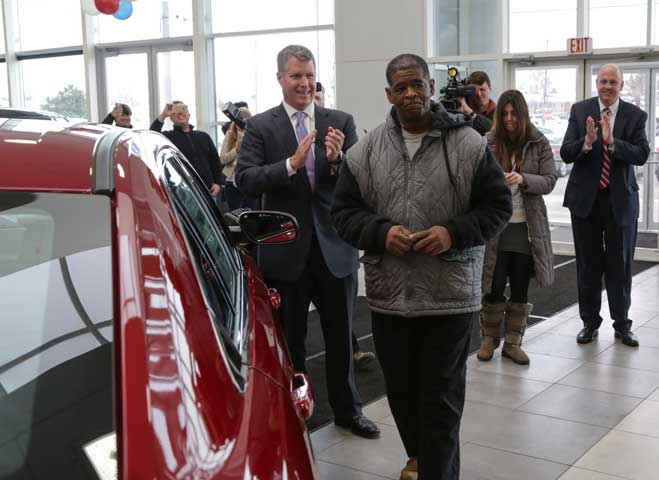 James Robertson of Detroit walks around his new free 2015 Ford Taurus following a Detroit Free Press story of Robertson’s 21-mile walk to and from work. (Newscom/ZUMA Press/Ryan Garza)
