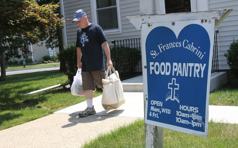A man carries shopping bags of food he received during a visit to the parish social ministry office at St. Frances Cabrini Church in Coram, N.Y., in 2012. (CNS/Gregory A. Shemitz)