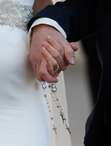 A newly married couple hold rosaries in their hands as they leave Pope Francis' general audience in St. Peter's Square at the Vatican Feb. 24. (CNS/Paul Haring)