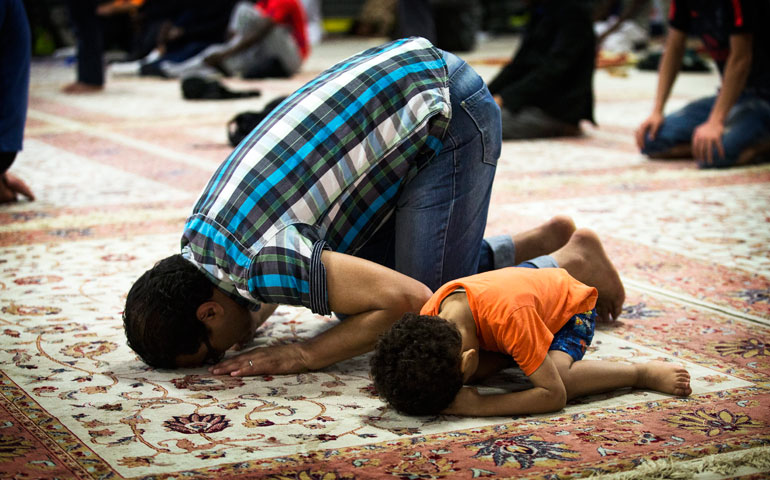 A father and son pray at the Muslim Sociocultural Institute in Paris in June. (Newscom/EPA/Etienne Laurent)
