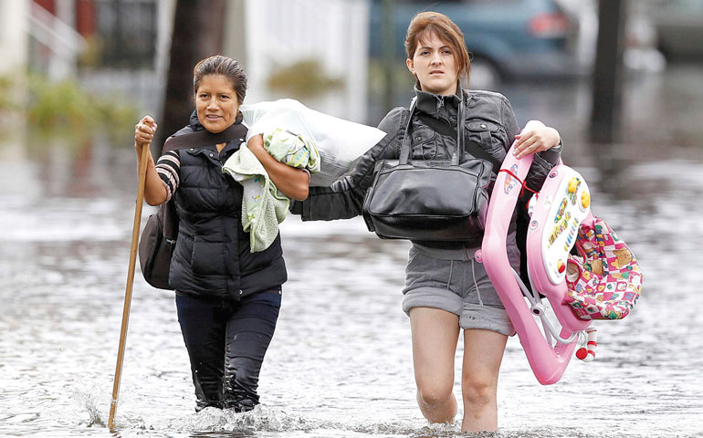 Residents make their way through flood waters brought on by Superstorm Sandy in Little Ferry, N.J., Oct. 30, 2012. (CNS/Reuters/Adam Hunger)