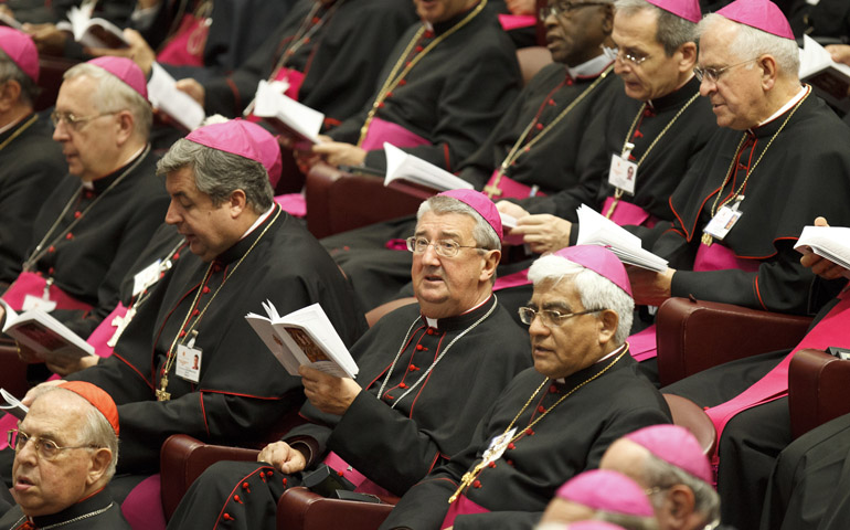 Archbishop Diarmuid Martin of Dublin, looking up from booklet, participates in opening prayer Friday during a meeting of the Synod of Bishops on the new evangelization at the Vatican. (CNS/Paul Haring) 