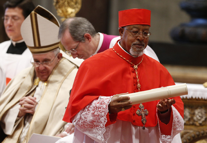 Cardinal Berhaneyesus Souraphiel of Addis Ababa, Ethiopia, carries his scroll after receiving his red biretta from Pope Francis during a consistory at which the pope created 20 new cardinals in St. Peter's Basilica at the Vatican Feb. 14. (CNS photo/Paul Haring)