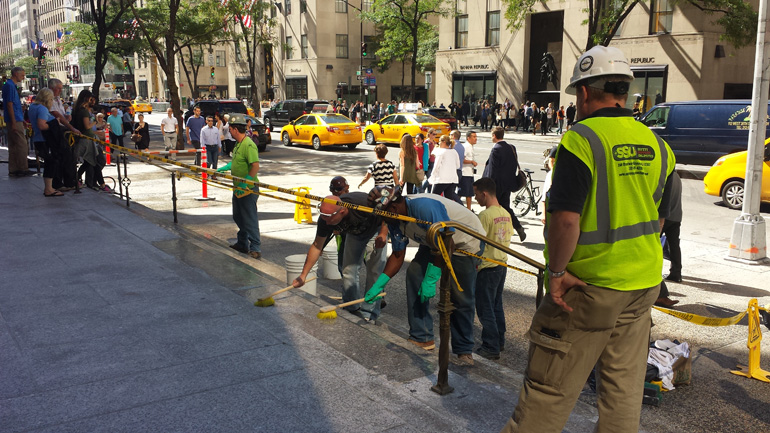 Workers clean the steps outside St. Patrick's Cathedral off Fifth Avenue in New York, just one day before Pope Francis' arrival. (Brian Roewe)
