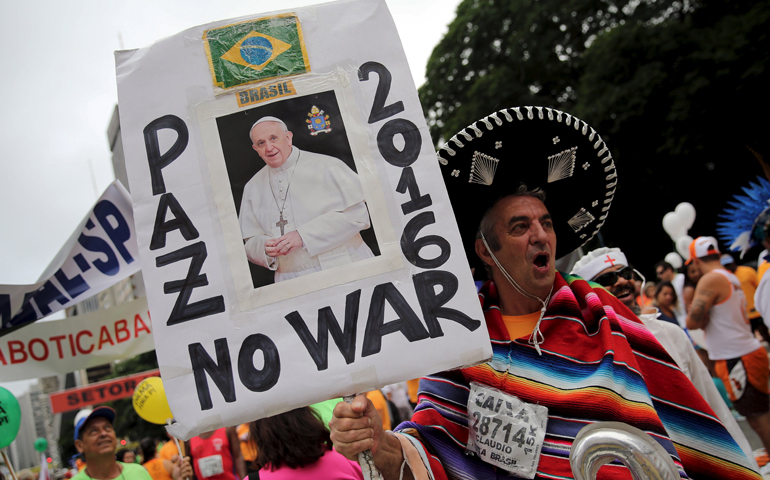 A runner holds a poster with the image of Pope Francis Dec. 31 before the annual St. Silvester Road Race in Sao Paulo. The poster reads "Peace, No War in 2016." (CNS/Nacho Doce, Reuters)