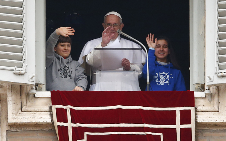 Pope Francis waves with two children as he leads his Angelus in St. Peter's Square at the Vatican Jan. 31. (CNS/Tony Gentile, Reuters)