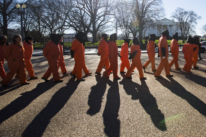 Activists dressed in orange jumpsuits representing detainees in the U.S.-run detention center at Guantanamo Bay, Cuba, rally in front of the White House Jan. 11 asking President Barack Obama to close the facility and release or charge the dozens of men being held there. (CNS/Jim Lo Scalzo, EPA) 