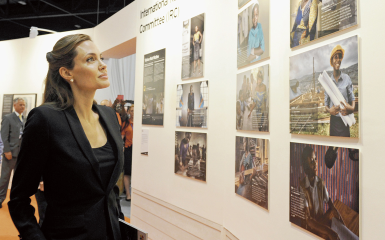 In London June 12, Angelina Jolie looks at photographs as she attends the Global Summit to End Sexual Violence in Conflict. (EPA/Facundo Arrizabalaga)