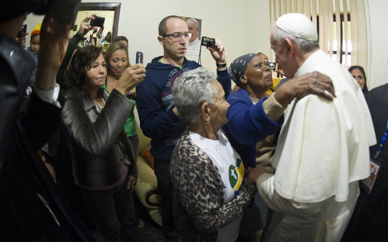 A woman embraces Pope Francis during a July 25 visit with residents at a home in the Varginha slum in Rio de Janeiro. (CNS/Reuters/L'Osservatore Romano)