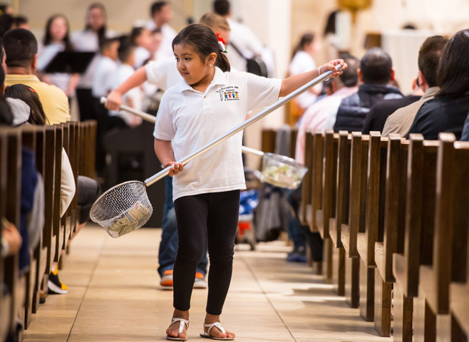 Yelixa Hernandez collects donations during Mass April 26 at St. Willebrord Church in Green Bay, Wis. Yelixa is a member of the parish's Hispanic youth group, Amigos de Jesus, that participates in liturgical ministries once a month and meets twice a month to learn more about the Mass and other church practices. (CNS/The Compass/Sam Lucero)