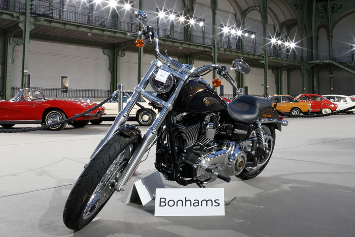 This Harley-Davidson Dyna Super Glide motorcycle, donated to Pope Francis in June, is displayed Wednesday as part of Bonham's Les Grandes Marques du Monde vintage and classic cars sale in Paris. Signed "Francesco" on its tank, was auctioned for charity Thursday in Paris. (CNS/Reuters/Benoit Tessier)