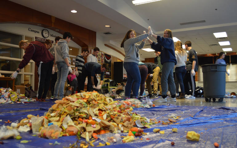 Students at Walsh Jesuit High School sort though a day's worth of garbage into piles of plastics, trash and uneaten food as part of a trash audit for the Ignatian Carbon Challenge. (WJ Green Team) 
