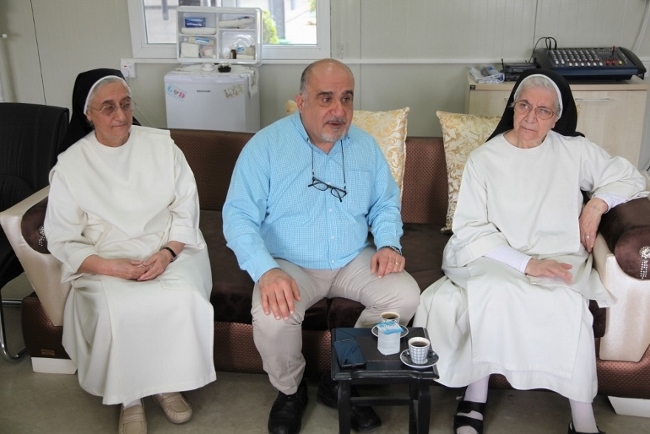 Dominican Sr. Maria Hanna, right, and Dominican Sr. Huda Chito,  with Michel Constantin, the CNEWA Beruit Regional Director, who served as an interpreter. (NCR photo/Tom Gallagher)