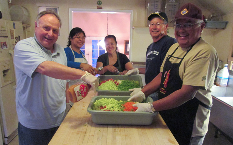 Jack Davis, left, and other Knights of Columbus and volunteers prepare salad for the Las Vegas Catholic Worker soup line. (Julia Occhiogrosso)