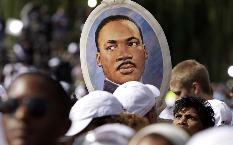 A woman holds a portrait of the Rev. Martin Luther King Jr. at the Oct. 16, 2011, dedication of a memorial to King in Washington. (CNS/Reuters/Yuri Gripas)