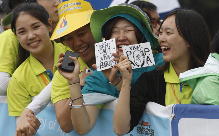 Young women wait for Pope Francis to arrive to celebrate the closing Mass of the sixth Asian Youth Day at Haemi Castle in Haemi, South Korea, Aug. 17. (CNS/Paul Haring)