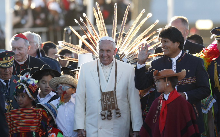 Pope Francis walks with Bolivian President Evo Morales and children in traditional dress as he arrives Wednesday at El Alto International Airport in La Paz, Bolivia. (CNS/Paul Haring)
