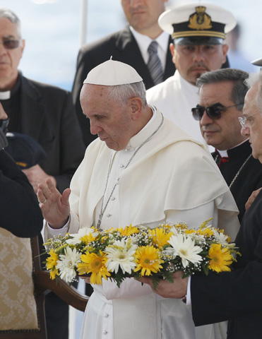 Pope Francis blesses a wreath Monday before tossing it into the Mediterranean Sea off the coast of Lampedusa, Italy. (CNS/Paul Haring) 