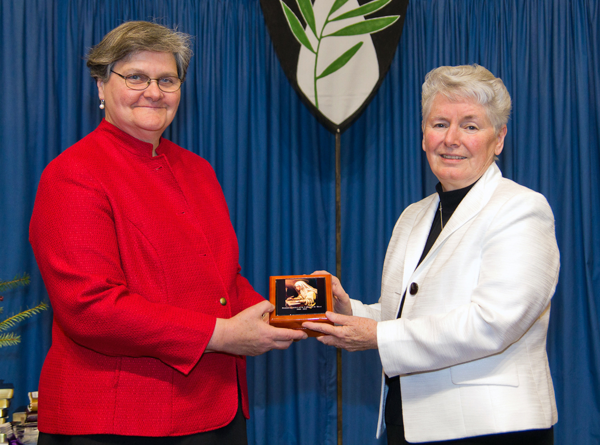 Outgoing de’ Ricci president Sr. Anne Lythgoe presents a “treasure box” to Dominican Sisters of Peace prioress Sr. Margaret Ormond, symbolizing the gifts the de’ Ricci Sisters bring. The merger ceremony took place Dec. 15 in Columbus, Ohio. (Photo from Dominican Sisters of Peace)