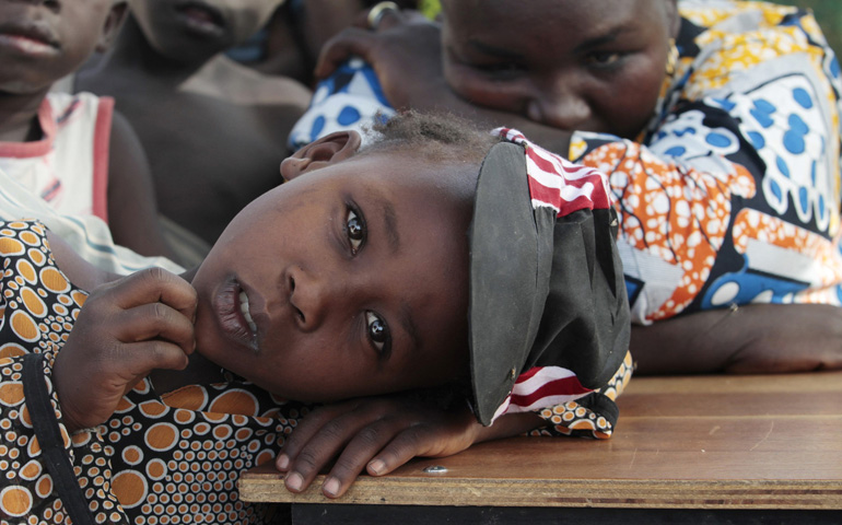 A girl displaced as a result of Boko Haram attack in the northeast region of Nigeria rests her head on a desk at a camp for internally displaced people Jan. 13 in Yola. (CNS/Reuters/Afolabi Sotunde)