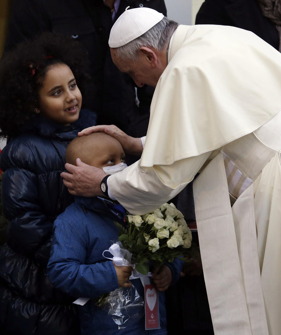 Pope Francis embraces sick child at Rome's Bambino Gesù hospital Dec. 21