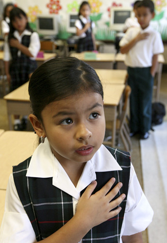 Briana Tena, a first-grade student at St. Mary of Czestochowa School in Cicero, Ill., joins her classmates in the Pledge of Allegiance during the first day of school in 2007. (CNS/Catholic New World/Karen Callaway)