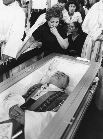 Salvadoran Archbishop Oscar Romero's sister cries over his coffin March 30, 1980. (Scan of CNS file photo)