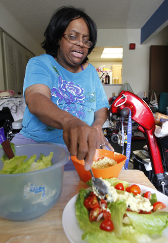 Denise Green prepares her salad for lunch at her home in Silver Spring, Md., in June. She purchases her food with help of the Supplemental Nutrition Assistance Program, formerly known as food stamps. (CNS/Bob Roller) 