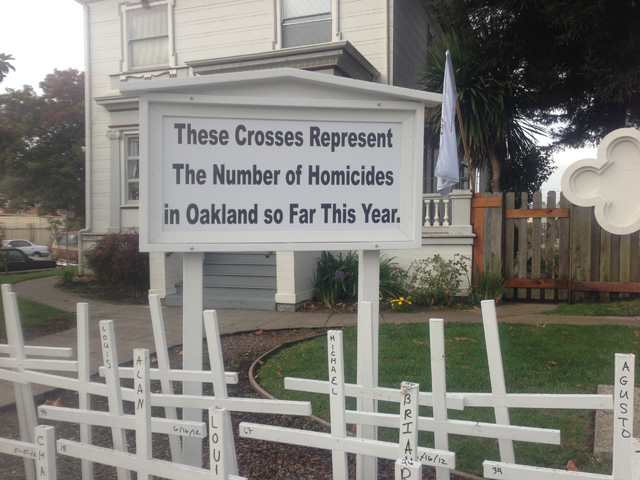 The sign in front of the St. Columba Parish rectory explains the crosses erected for every Oakland, Calif., homicide victim during a given year. (Courtesy of Rich Laufenberg)