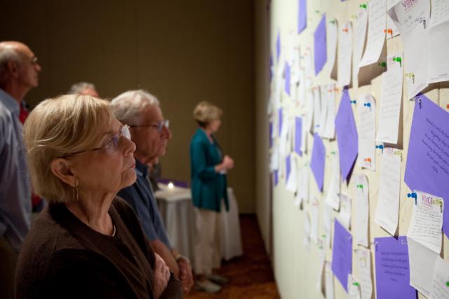 A woman looks at notes left on the Lamentation Wall at the 10th annual Voice of the Faithful gathering in Boston. (©VOTF/Jason Bergman)